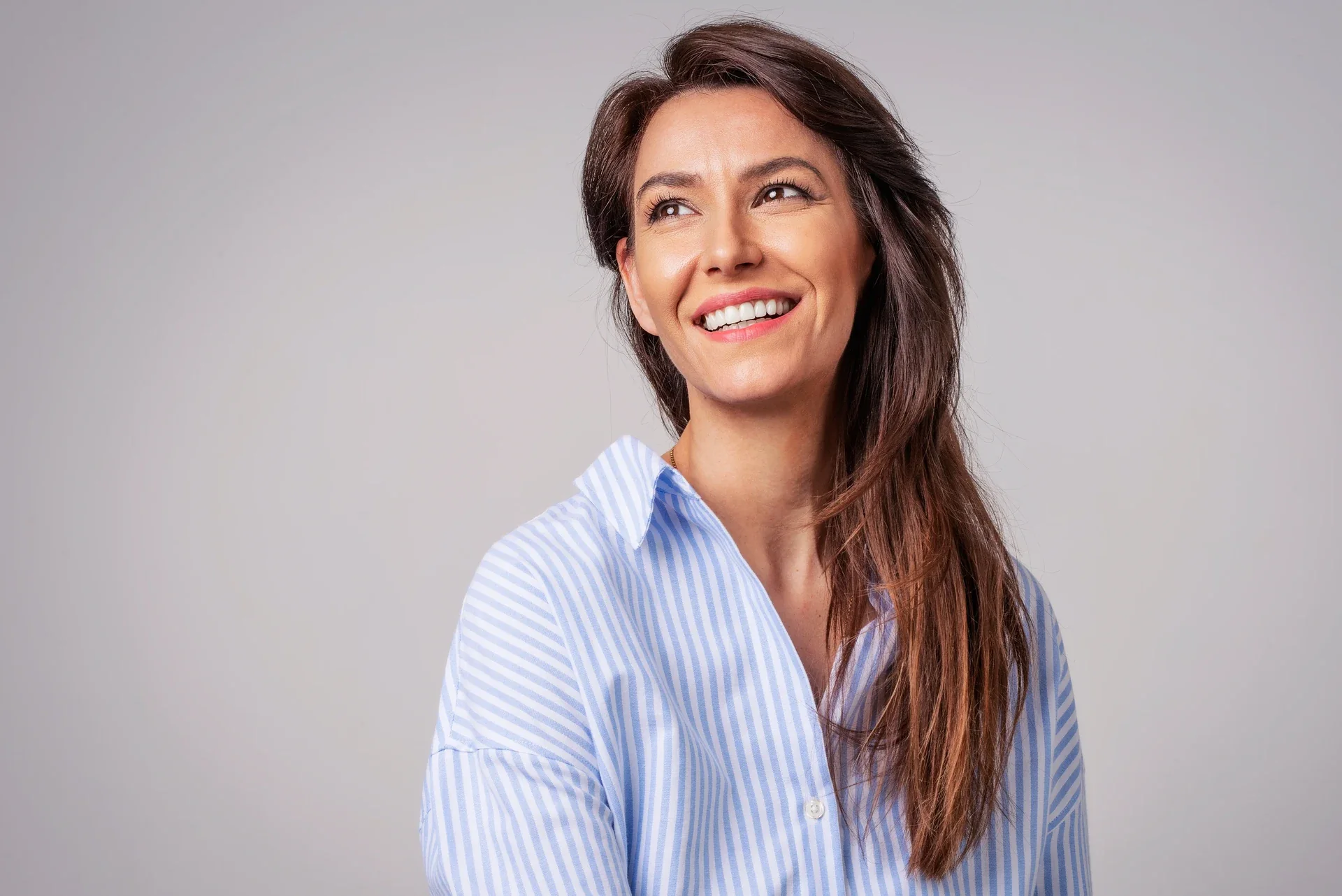 Portrait of a smiling woman in a blue shirt.