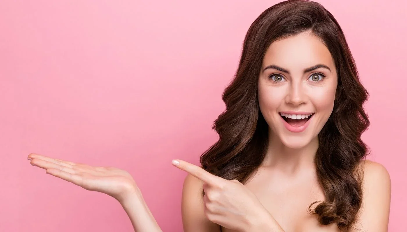 Smiling woman pointing to the side.