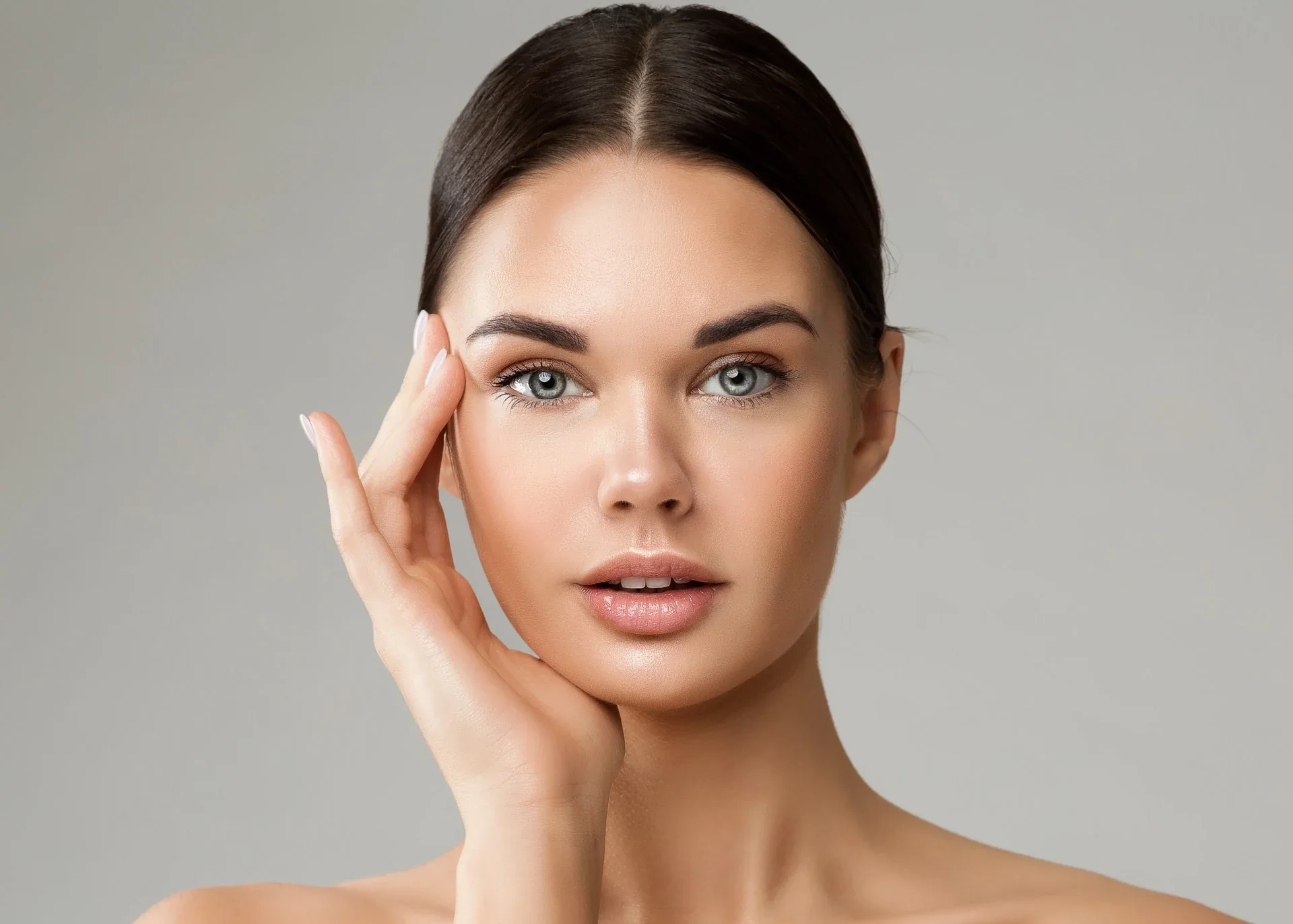Woman gently touching the side of her face.